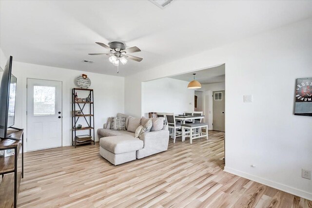 living room featuring light hardwood / wood-style flooring and ceiling fan