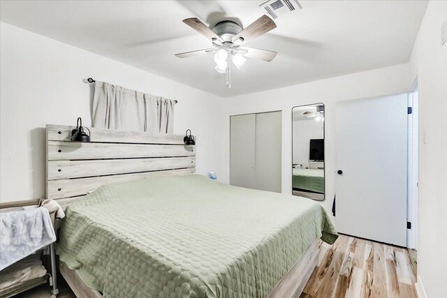 bedroom featuring ceiling fan, light hardwood / wood-style floors, and a closet