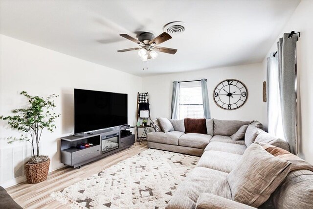 living room with ceiling fan and light hardwood / wood-style flooring