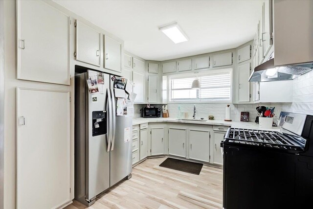 kitchen featuring backsplash, black range with electric stovetop, sink, range hood, and stainless steel fridge with ice dispenser