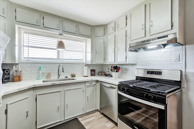 kitchen with backsplash, a healthy amount of sunlight, sink, and stainless steel appliances