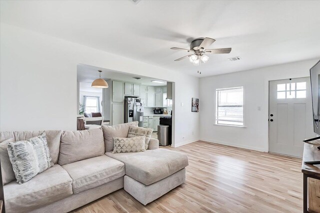 living room featuring ceiling fan, a healthy amount of sunlight, and light hardwood / wood-style floors