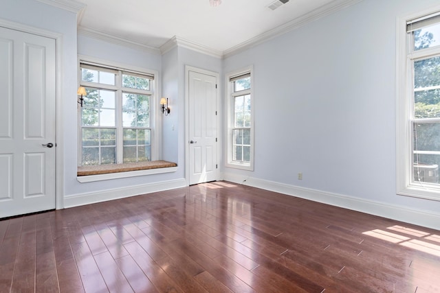 empty room featuring dark hardwood / wood-style floors and crown molding