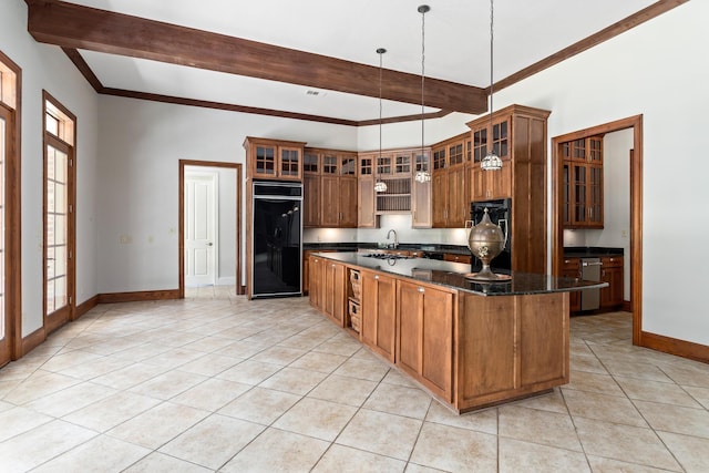 kitchen featuring dark stone counters, light tile patterned floors, a center island, built in refrigerator, and hanging light fixtures