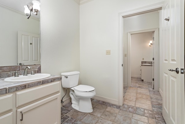 bathroom featuring vanity, toilet, and ornamental molding