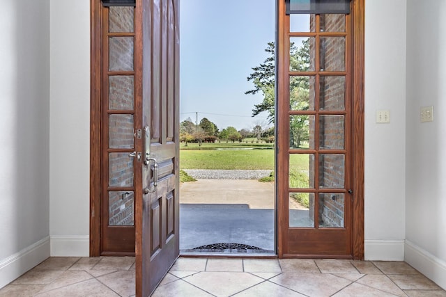 doorway to outside with light tile patterned floors and french doors