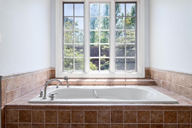 bathroom featuring tiled bath and plenty of natural light