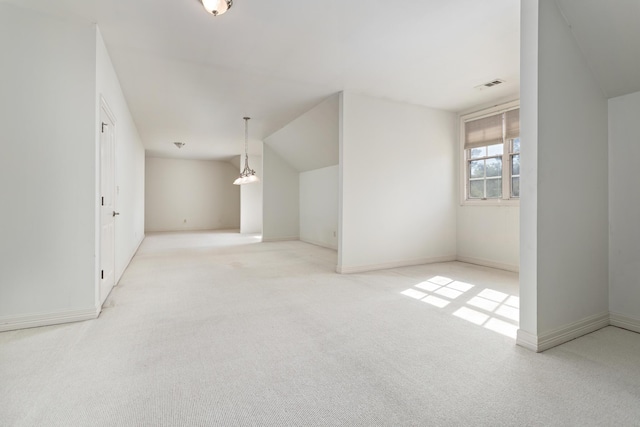 carpeted empty room with vaulted ceiling