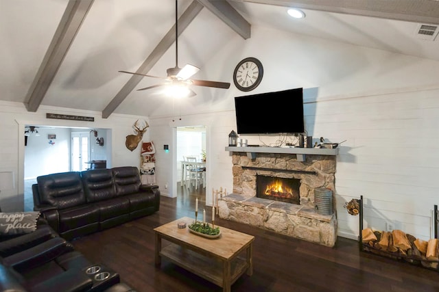 living room featuring dark hardwood / wood-style flooring, ceiling fan, beam ceiling, high vaulted ceiling, and a stone fireplace