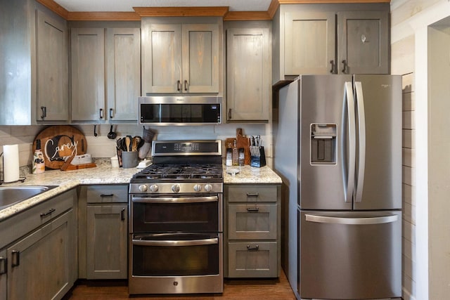 kitchen featuring gray cabinetry, light stone countertops, and appliances with stainless steel finishes