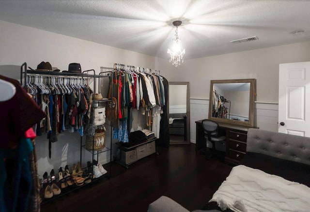 spacious closet featuring a notable chandelier and dark hardwood / wood-style floors