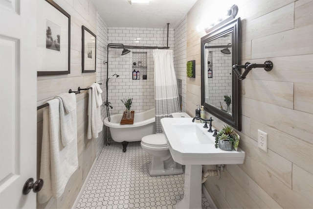 bathroom featuring tile patterned flooring, shower / tub combo, and toilet