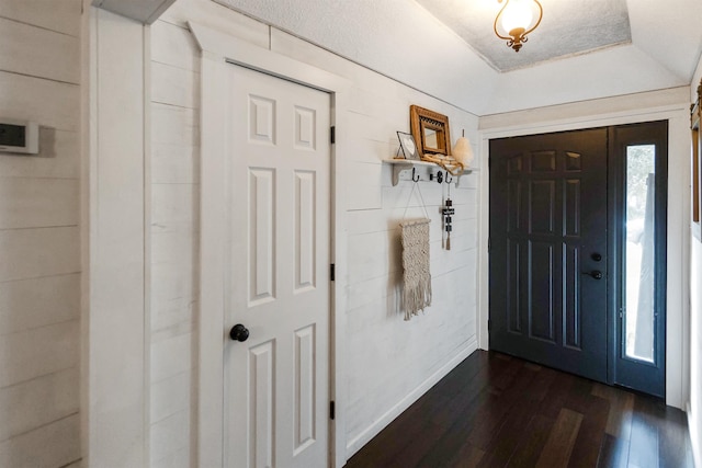 entryway with a tray ceiling, a wealth of natural light, and dark hardwood / wood-style floors