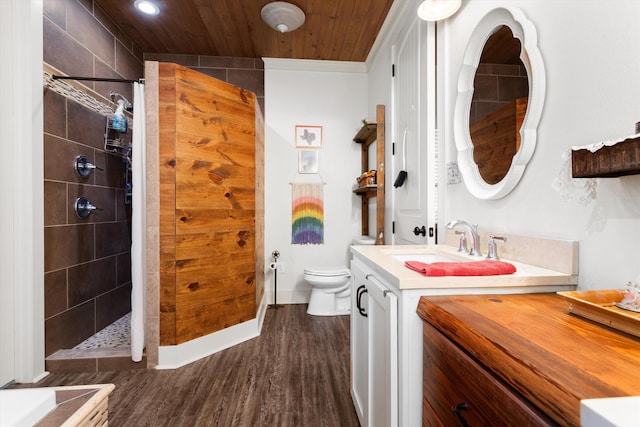 bathroom with wood ceiling, vanity, tiled shower, wood-type flooring, and toilet