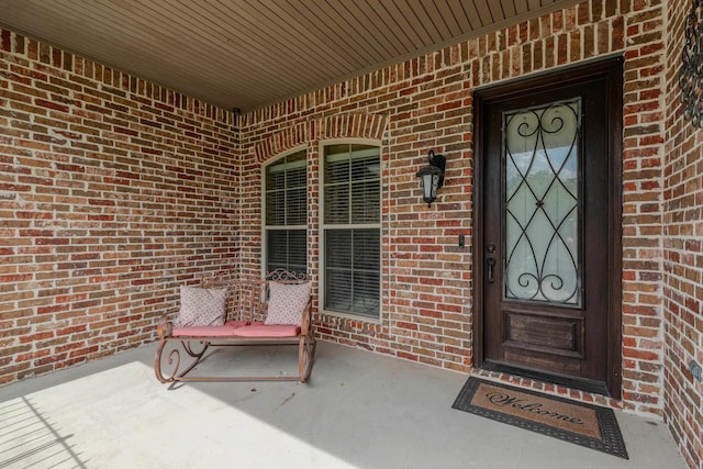 view of exterior entry featuring covered porch