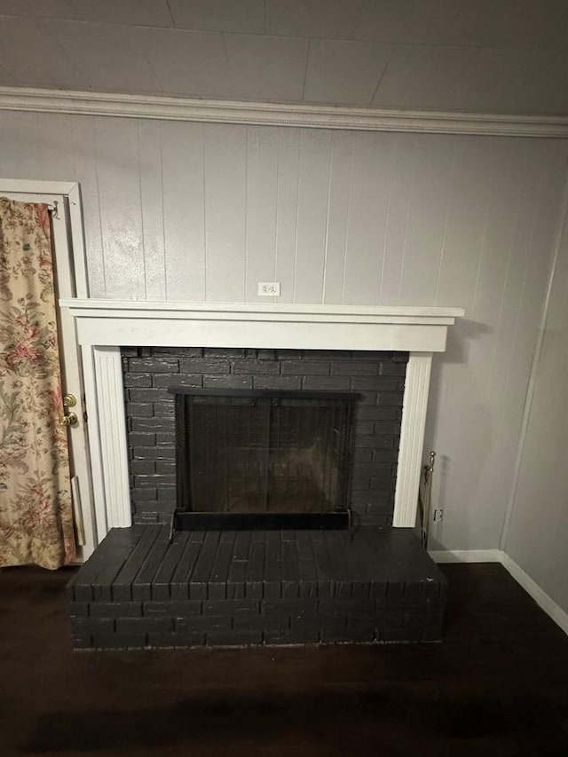 interior details featuring a fireplace, ornamental molding, and wood walls