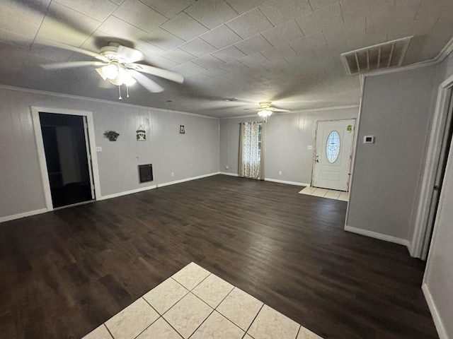 unfurnished living room featuring dark hardwood / wood-style floors, ceiling fan, and crown molding