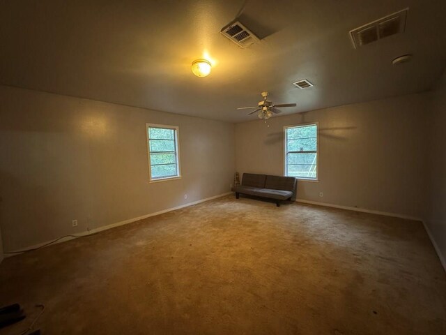 spare room with ceiling fan, plenty of natural light, and carpet