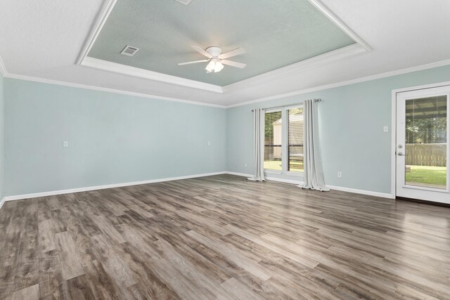 12795 Tanoak Ln, Beaumont, TX 77713 - unfurnished room featuring a tray ceiling, plenty of natural light, ceiling fan, wood finished floors, and ornamental molding