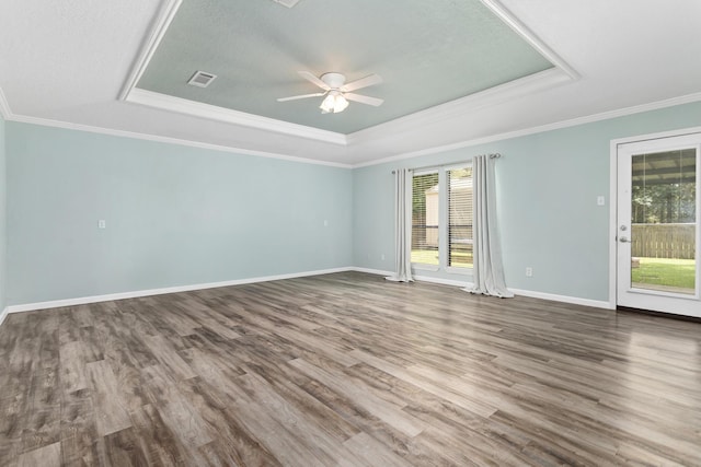 12795 Tanoak Ln, Beaumont, TX 77713 - unfurnished room featuring a tray ceiling, plenty of natural light, ceiling fan, wood finished floors, and ornamental molding