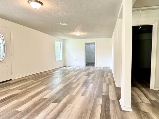 interior space featuring light hardwood / wood-style flooring and a textured ceiling