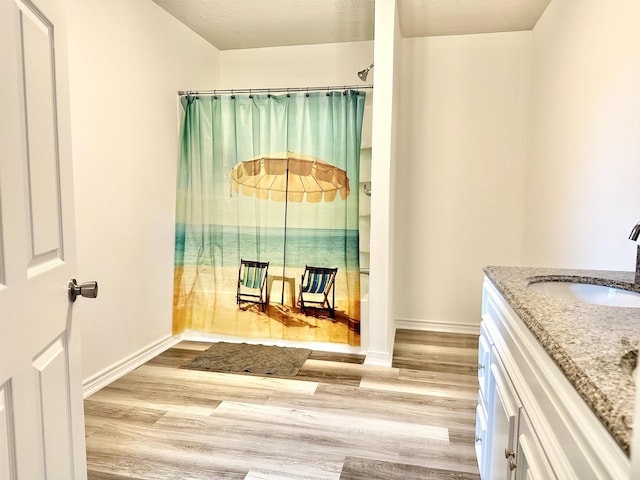 bathroom featuring bathtub / shower combination, hardwood / wood-style floors, vanity, and a textured ceiling