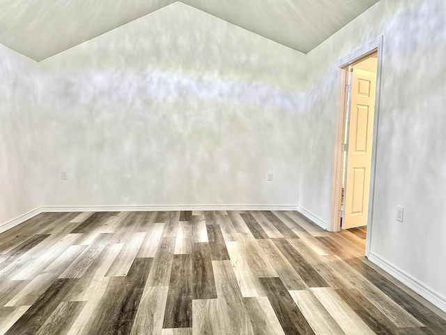 unfurnished room featuring wood-type flooring and lofted ceiling