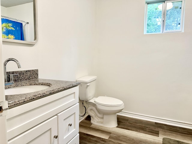 bathroom featuring wood-type flooring, vanity, and toilet