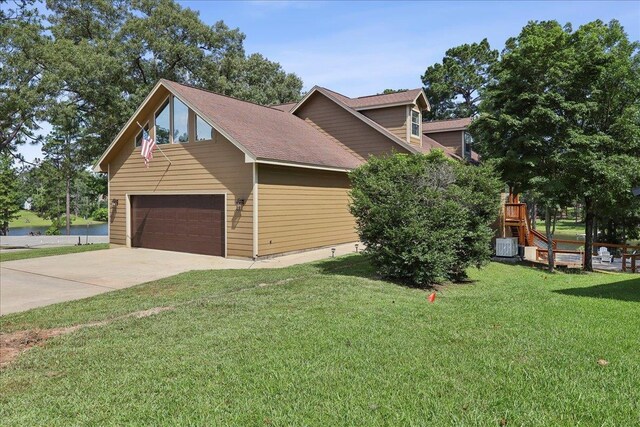 243 Riverbirch, Brookeland, TX 75931 - view of property exterior with a lawn, driveway, a garage, and a water view