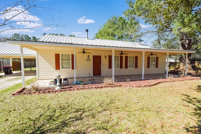 view of front of home with ceiling fan, metal roof, an attached carport, fence, and a front lawn