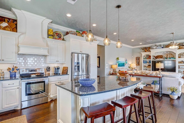 kitchen featuring backsplash, white cabinets, stainless steel appliances, and custom range hood