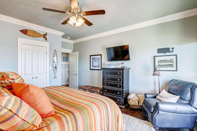 bedroom featuring dark wood-type flooring, a closet, ceiling fan, and ornamental molding