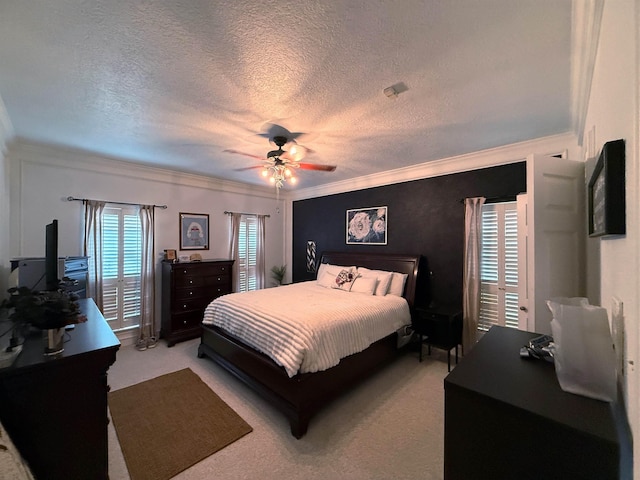 carpeted bedroom with ceiling fan, crown molding, and a textured ceiling