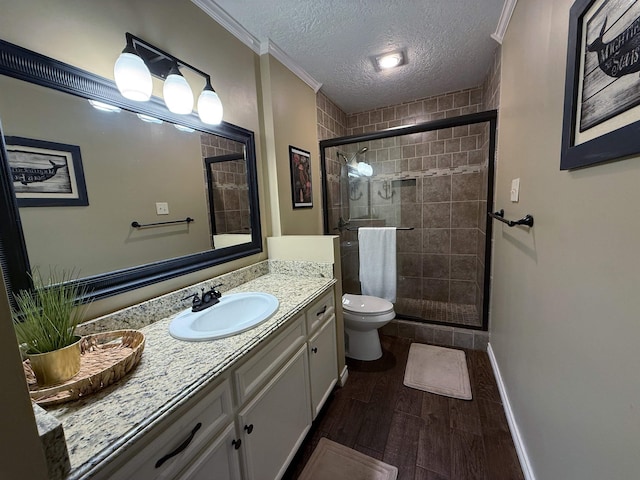 bathroom featuring an enclosed shower, toilet, a textured ceiling, vanity, and ornamental molding