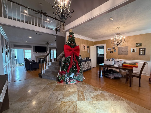 dining space featuring wood-type flooring, a textured ceiling, ceiling fan, and ornamental molding