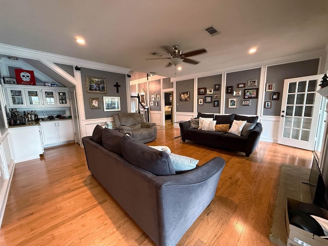 living room featuring light hardwood / wood-style flooring, ceiling fan, and ornamental molding