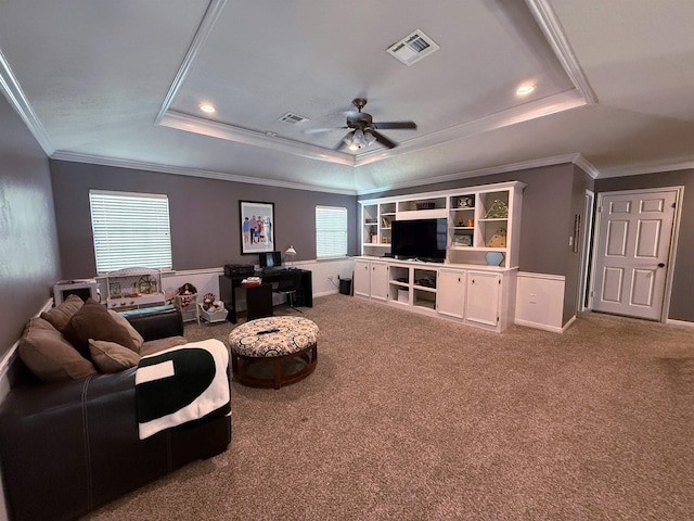 carpeted living room featuring ceiling fan, crown molding, and a tray ceiling