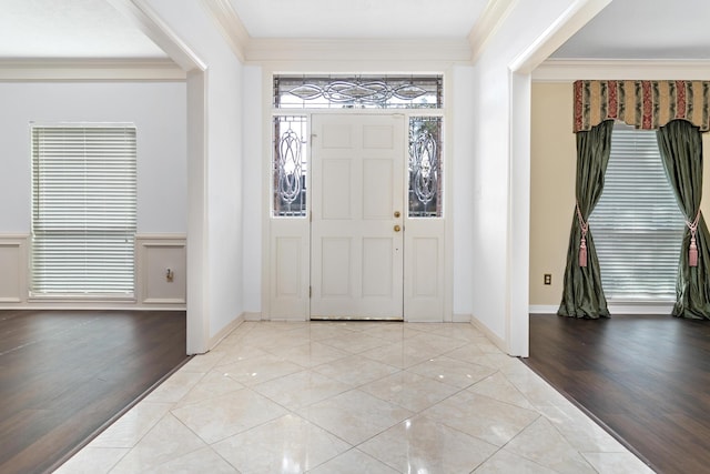 foyer featuring light tile patterned floors and ornamental molding