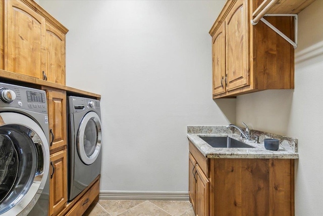 laundry room featuring sink, washer and clothes dryer, and cabinets