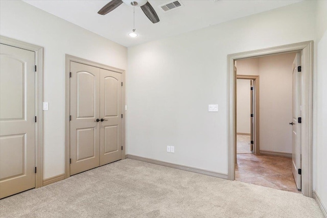 unfurnished bedroom with ceiling fan and light colored carpet