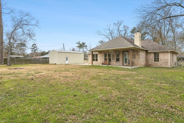 rear view of property with a yard and an outdoor structure