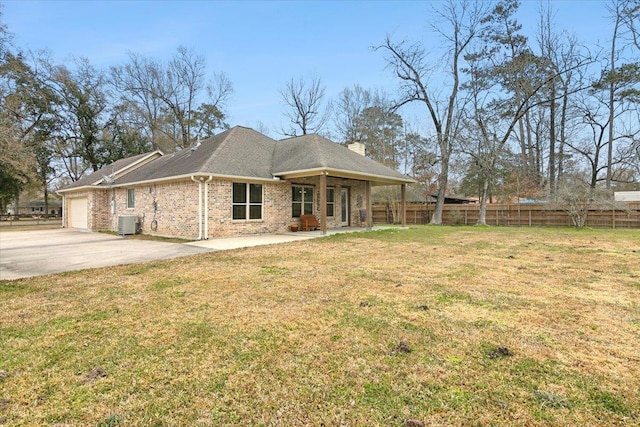 view of front facade featuring central AC unit, a garage, and a front yard