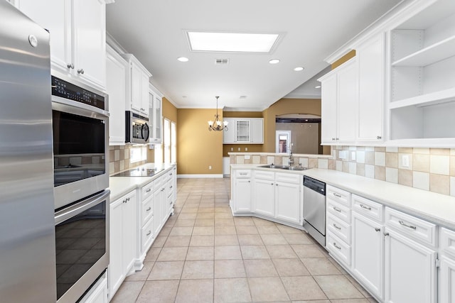 kitchen with decorative light fixtures, a healthy amount of sunlight, white cabinetry, and stainless steel appliances