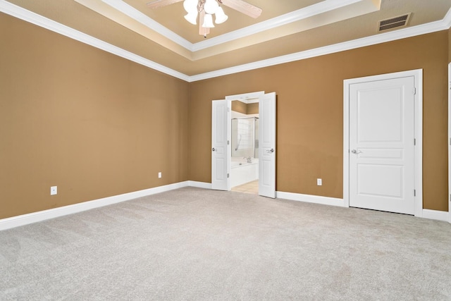 carpeted empty room featuring a tray ceiling, ceiling fan, and ornamental molding