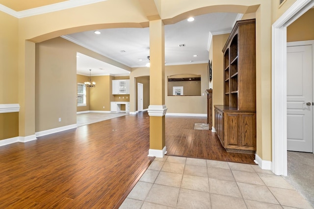 unfurnished living room with light tile patterned floors, ceiling fan with notable chandelier, and ornamental molding