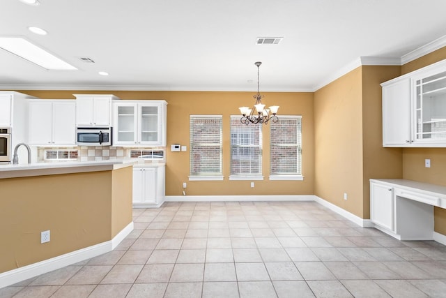 kitchen with stainless steel oven, crown molding, decorative backsplash, a notable chandelier, and white cabinetry