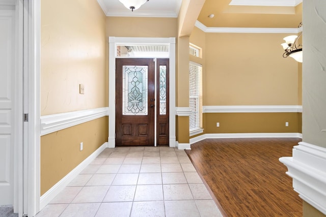 foyer with light tile patterned floors and ornamental molding