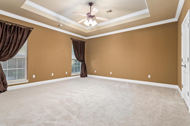 carpeted empty room featuring a tray ceiling, ceiling fan, and ornamental molding