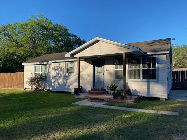 view of front of home featuring fence and a front lawn