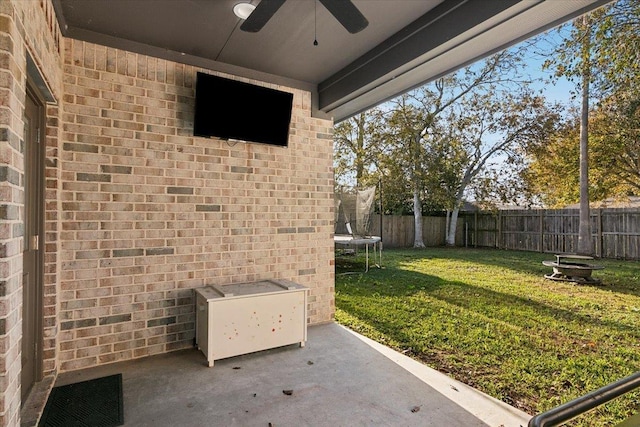 view of yard with a trampoline and ceiling fan